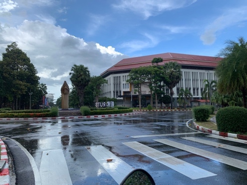 A building with a red roof and a crosswalk in front of it

Description automatically generated