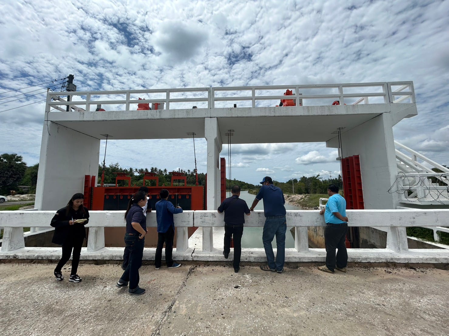 A group of people standing around a white structure

Description automatically generated