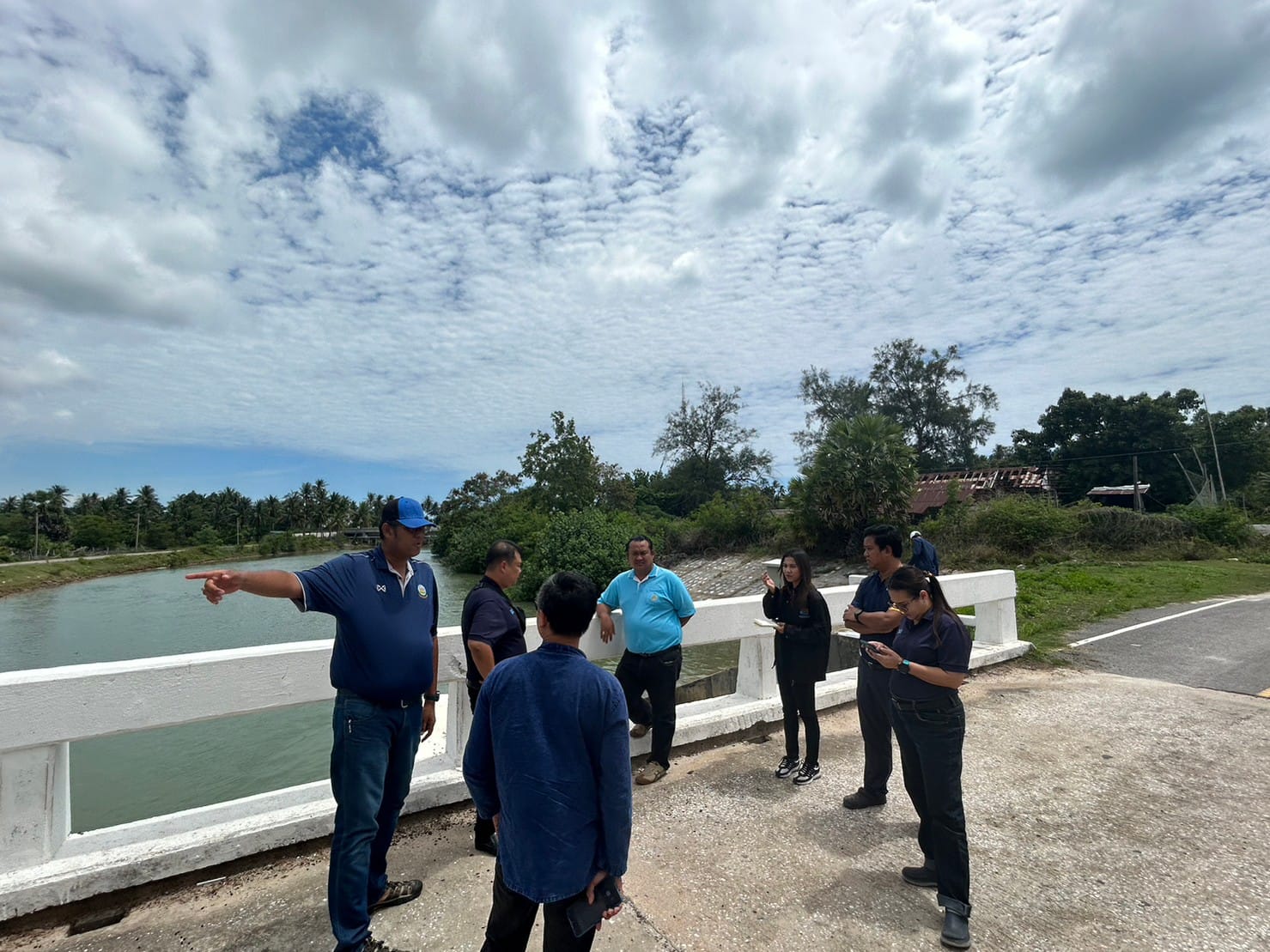 A group of people standing on a bridge

Description automatically generated