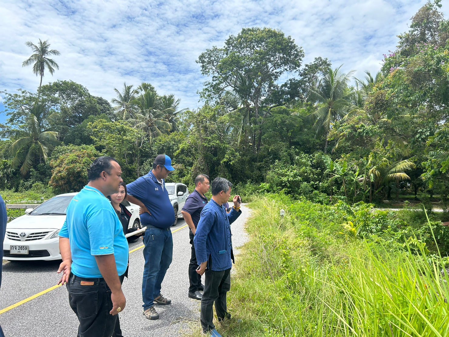 A group of people standing on a road

Description automatically generated