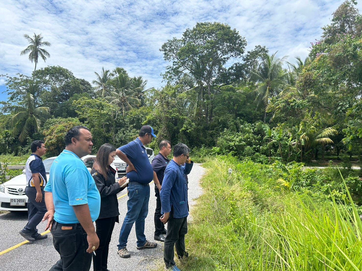 A group of people standing on a road

Description automatically generated