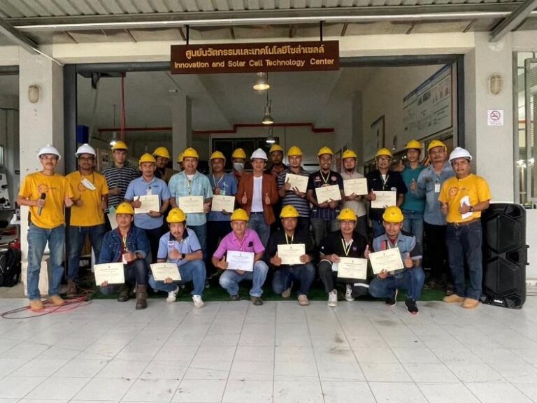 A group of people wearing hardhats holding signs Description automatically generated