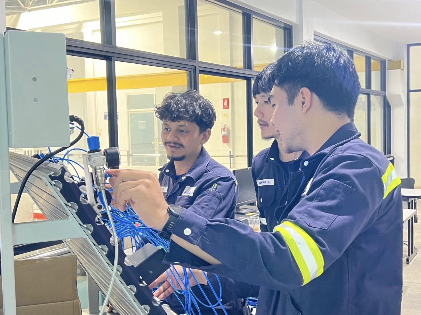 A group of men working on a machine
AI-generated content may be incorrect.