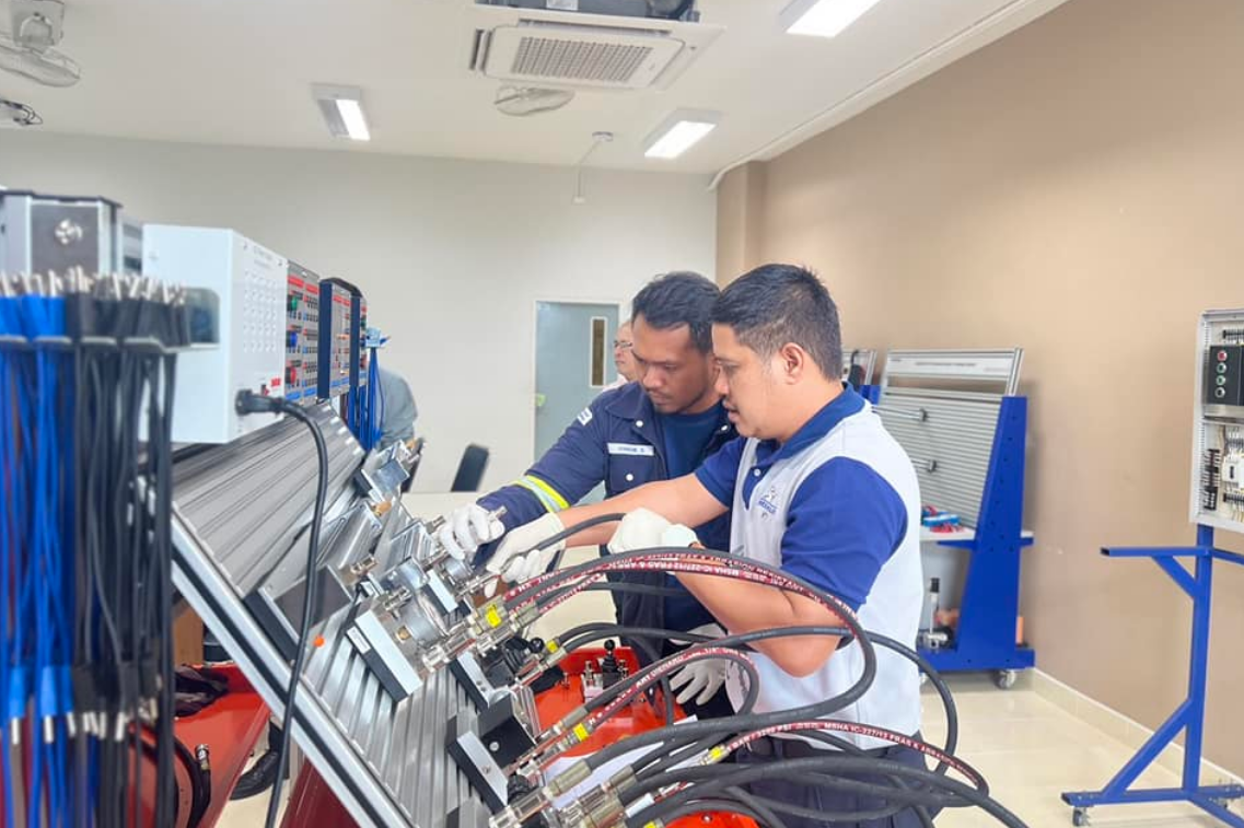 A group of men working on a machine
Description automatically generated