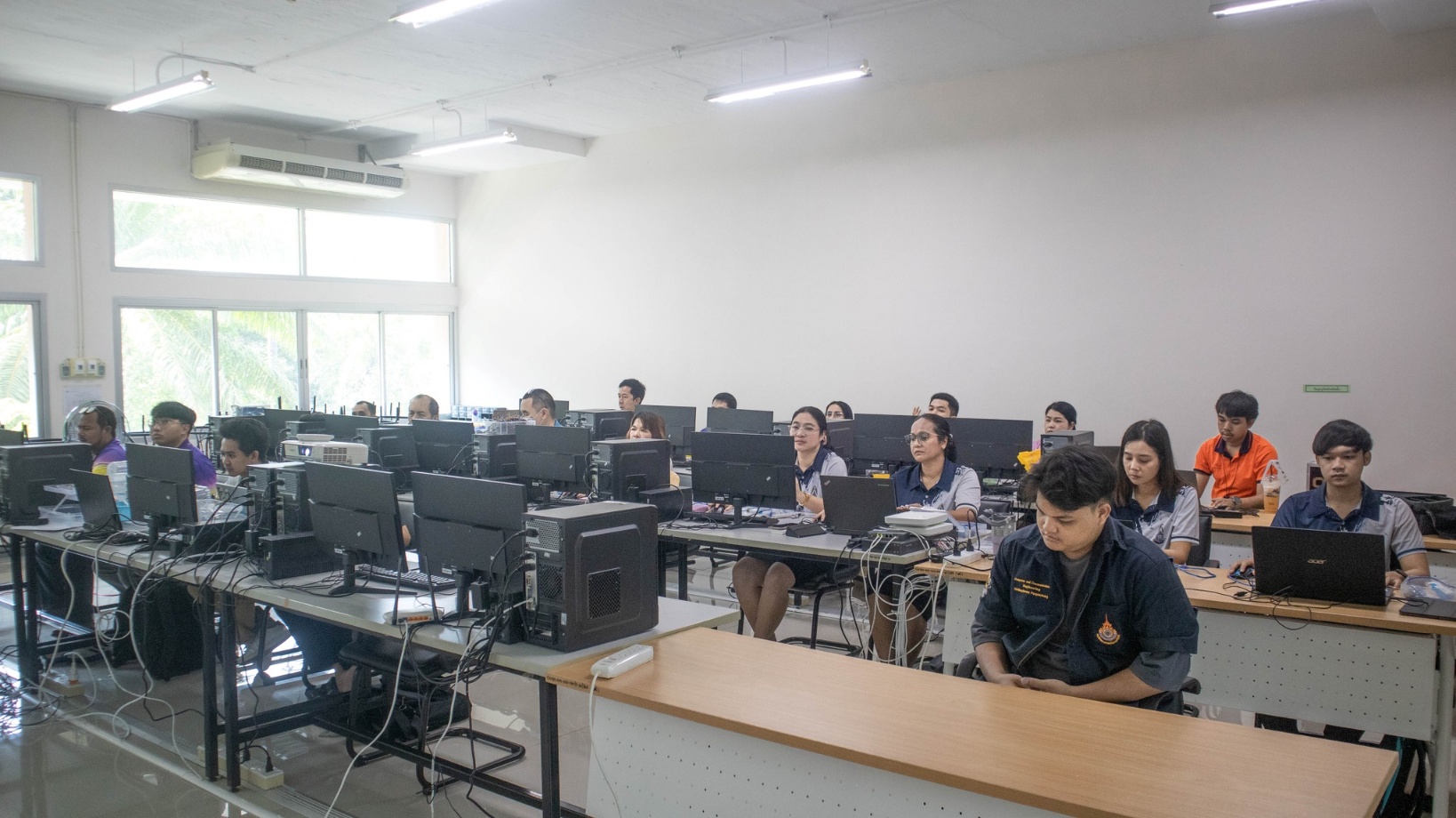 A group of people sitting at computers

AI-generated content may be incorrect.