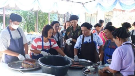 A group of people standing around a table
AI-generated content may be incorrect.