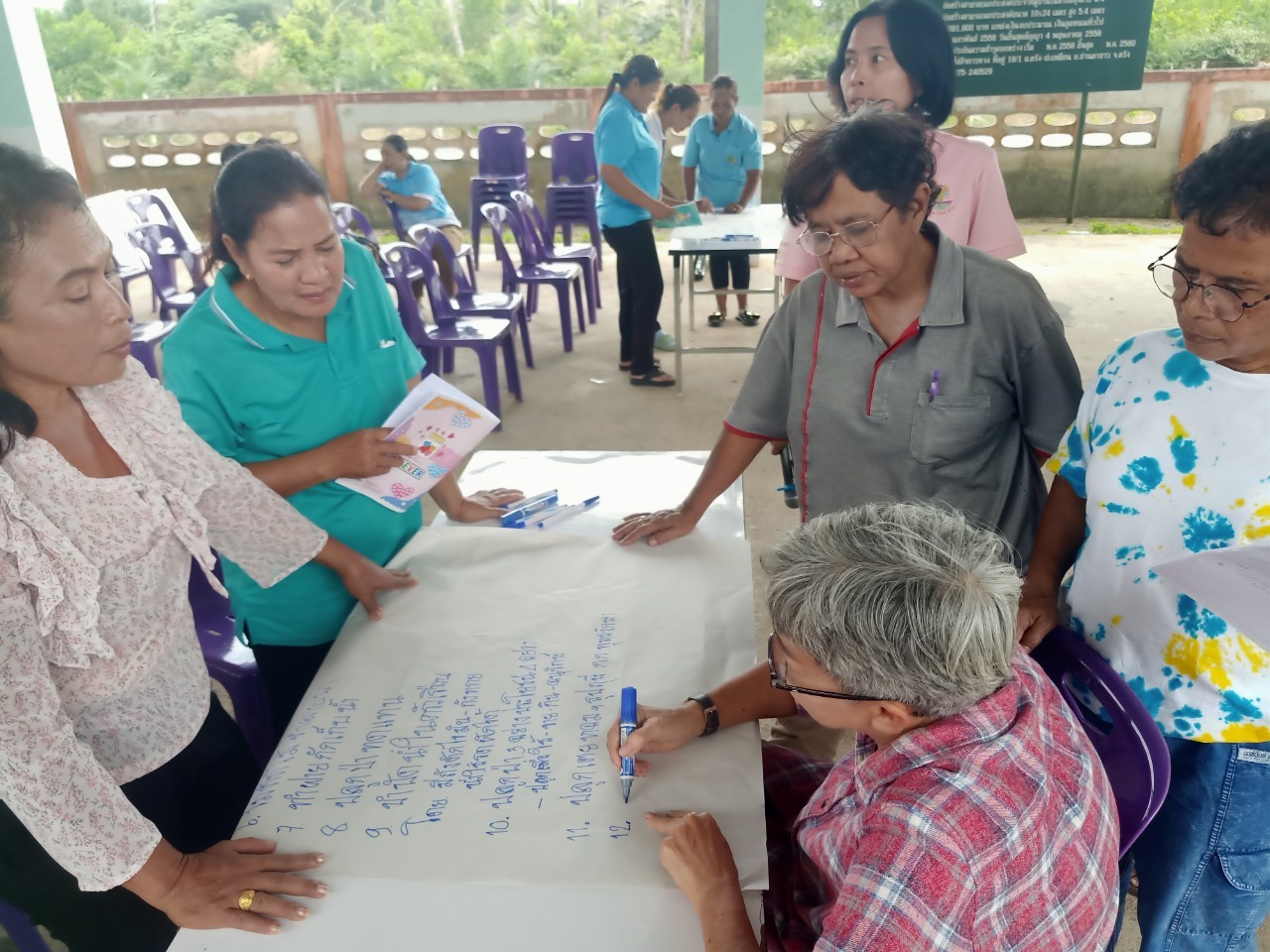 A group of people standing around a table

AI-generated content may be incorrect.