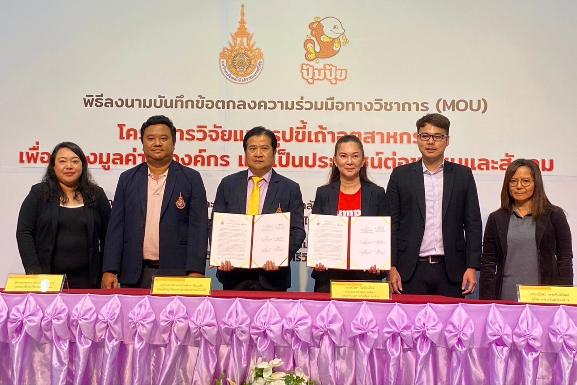 A group of people standing at a table with papers

AI-generated content may be incorrect.