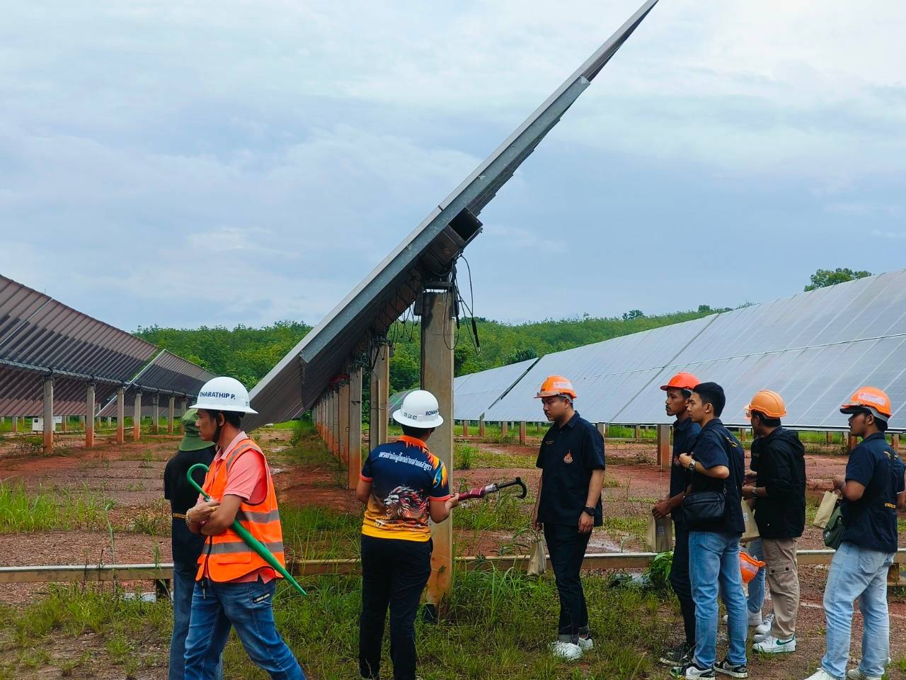 A group of people standing in front of solar panels

AI-generated content may be incorrect.