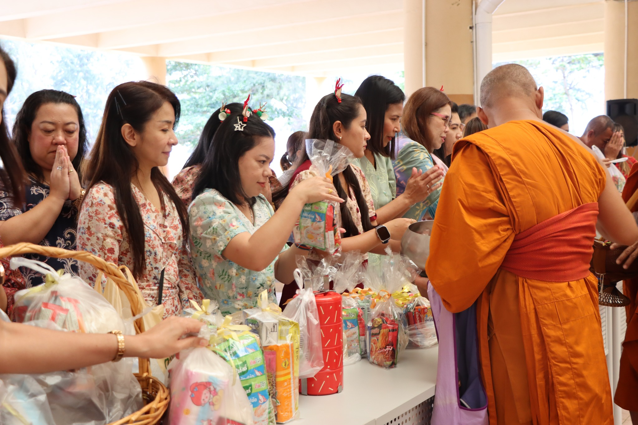 A group of people standing next to a table with food items
AI-generated content may be incorrect.