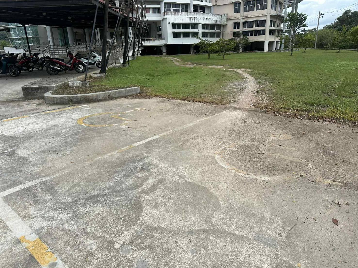 A parking lot with a building and grass
AI-generated content may be incorrect.