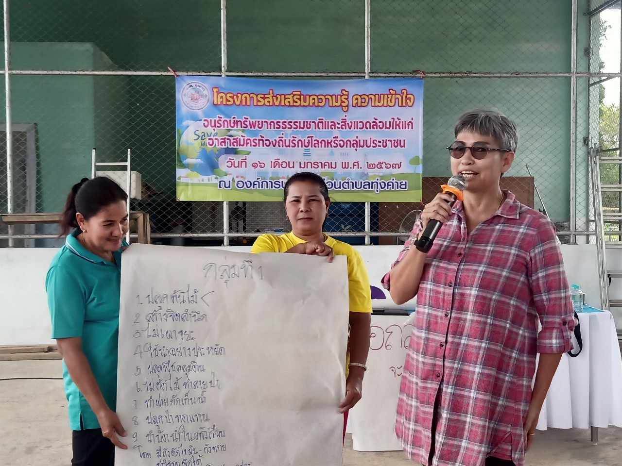 A person holding a microphone and a person holding a sign

AI-generated content may be incorrect.