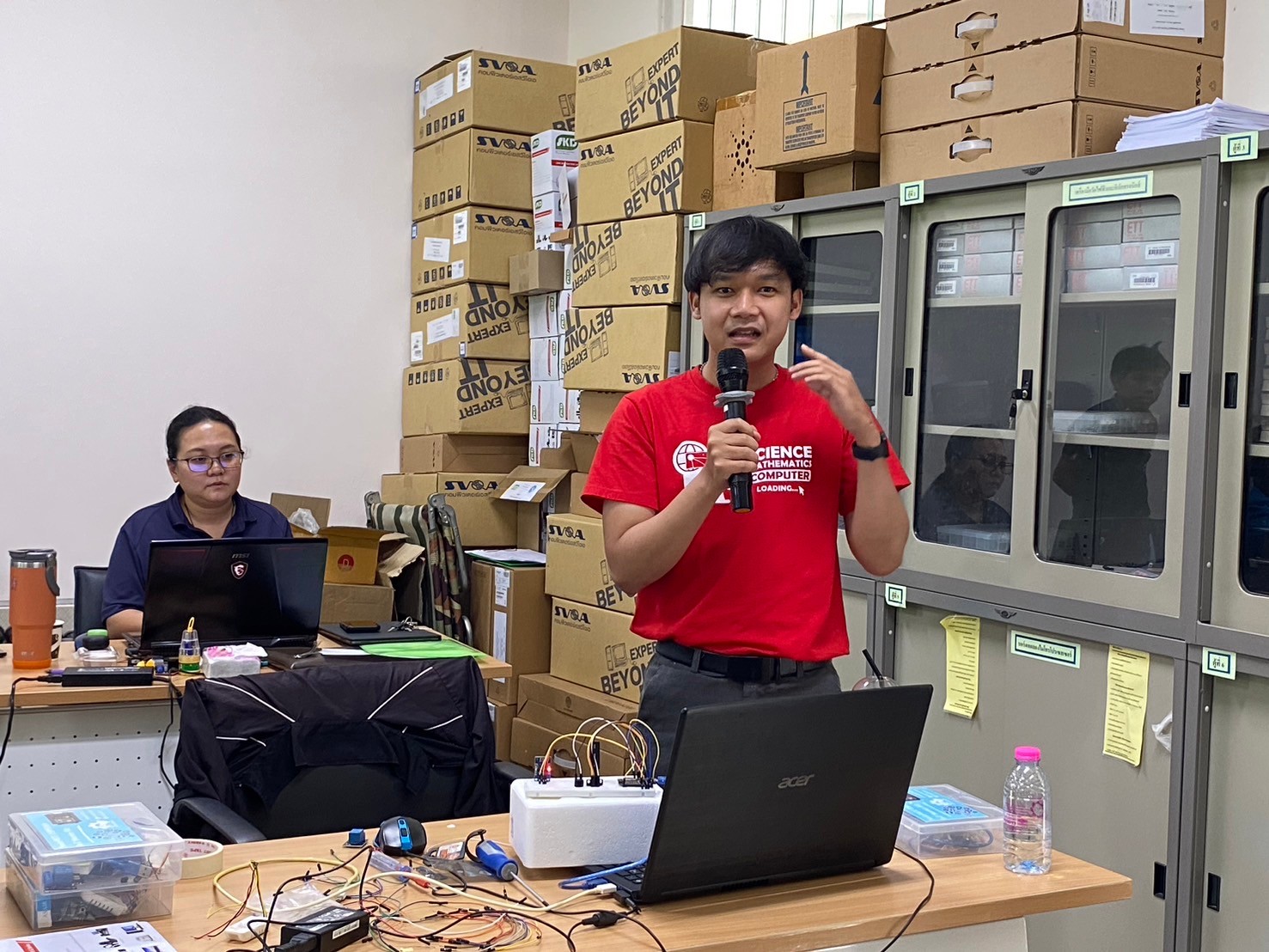 A person holding a microphone in front of a computer

AI-generated content may be incorrect.