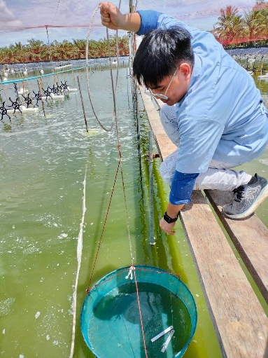 A person in a blue shirt and glasses squatting on a dock with a bucket of water
AI-generated content may be incorrect.